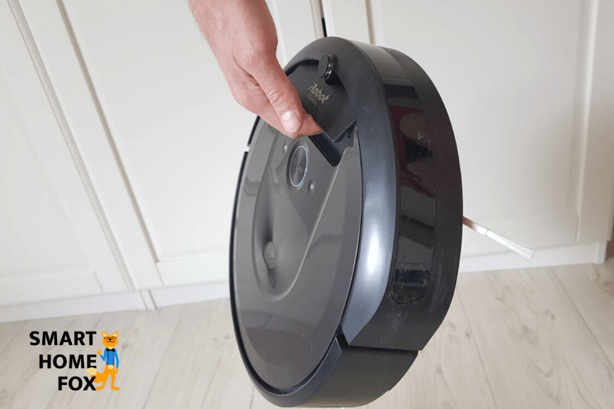 Der iRobot Roomba i7 wird mit Hilfe des Tragegriffs hochgehoben